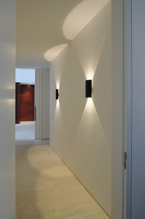 Un pasillo largo con dos luces en la pared.