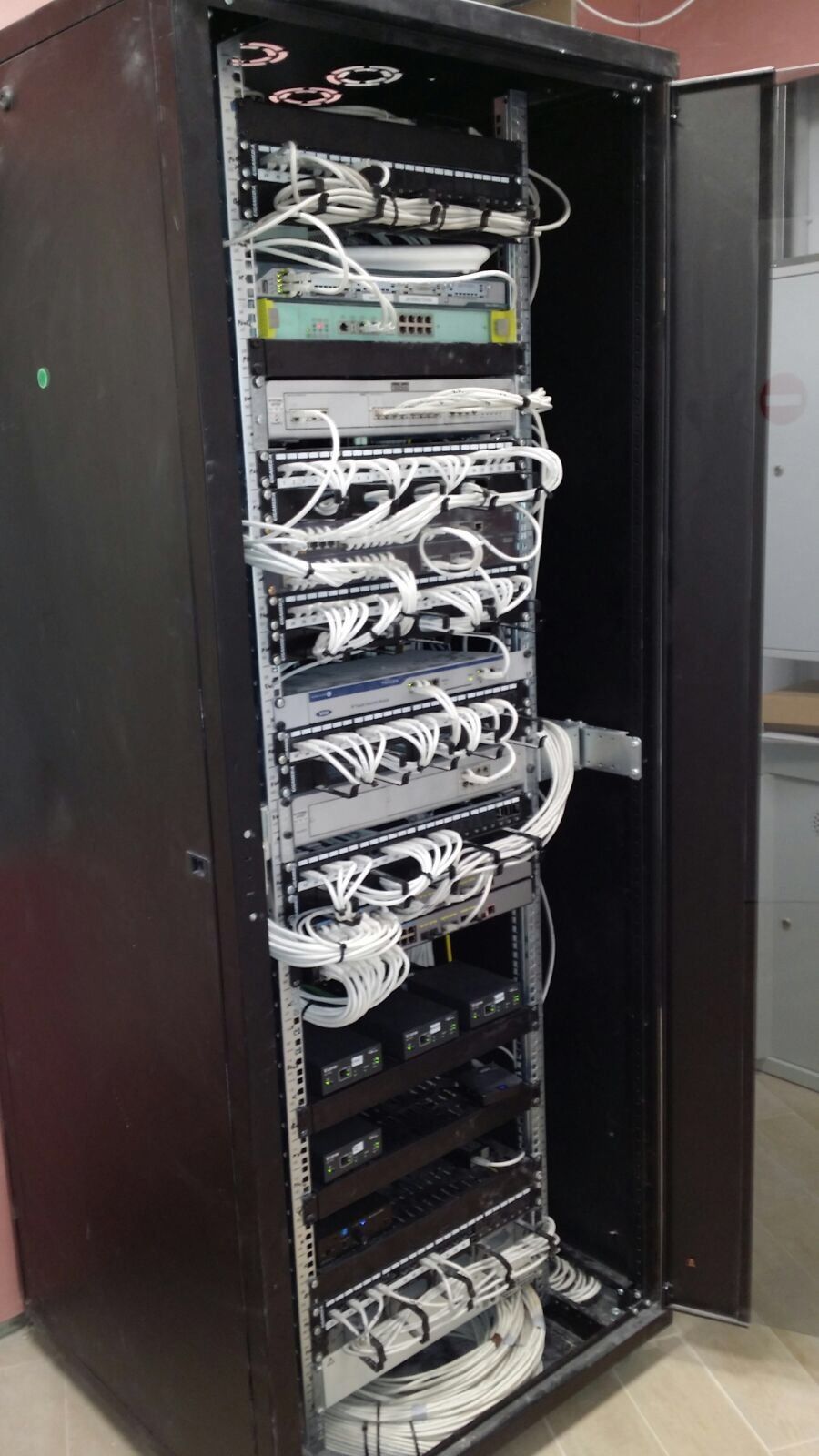 Un rack de servidores con muchos cables saliendo de él.